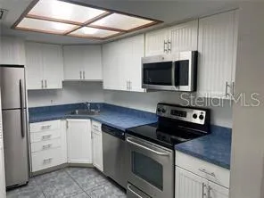 a kitchen with cabinets stainless steel appliances and a counter space