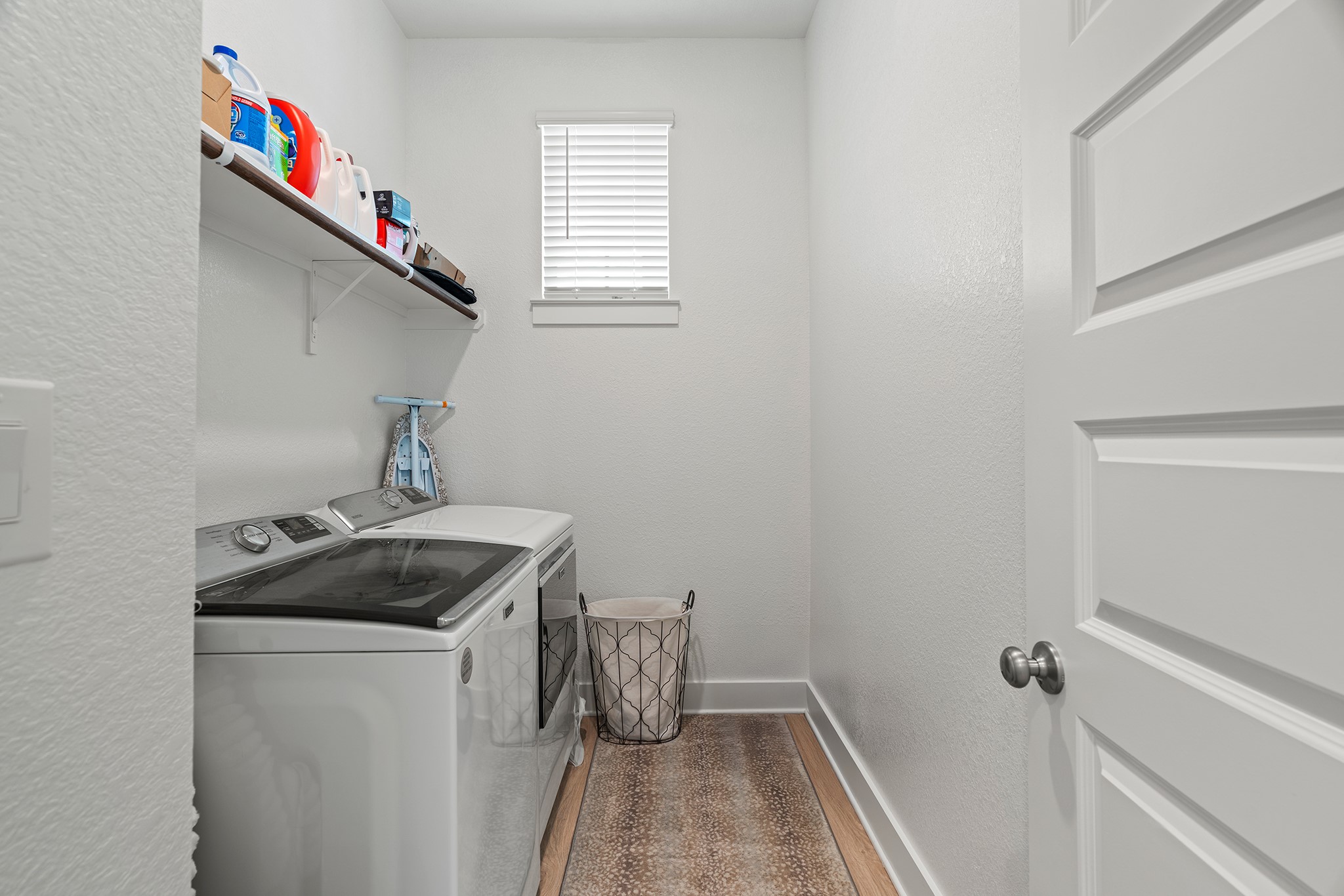 2112 Tobiano Trace Georgetown, TX 78633 - Photo 26 of 40 Washroom with light wood finished floors, a textured wall, and separate washer and dryer