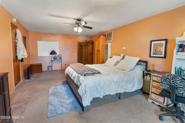 a spacious bedroom with a bed and a chandelier