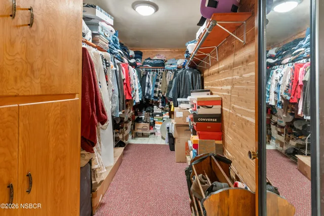a view of walk in closet with clothes