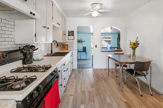 a kitchen with stainless steel appliances granite countertop a stove and white cabinets