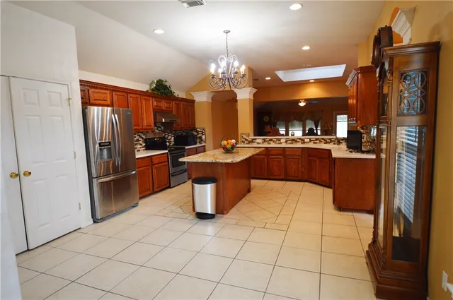 a kitchen with stainless steel appliances granite countertop a stove a sink and a refrigerator