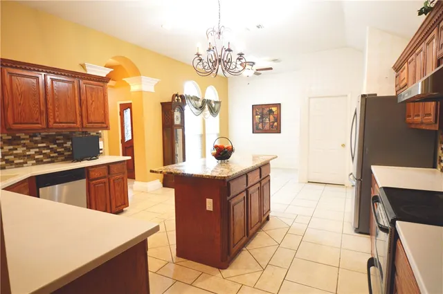 a large kitchen with stainless steel appliances kitchen island granite countertop a sink and cabinets