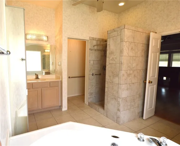 a bathroom with a tub shower and sink