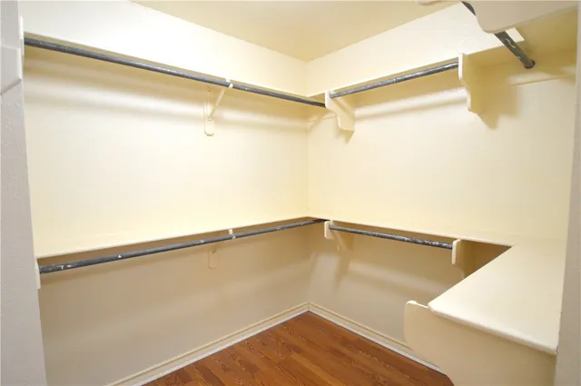 a view of walk in closet with clothes and shoes