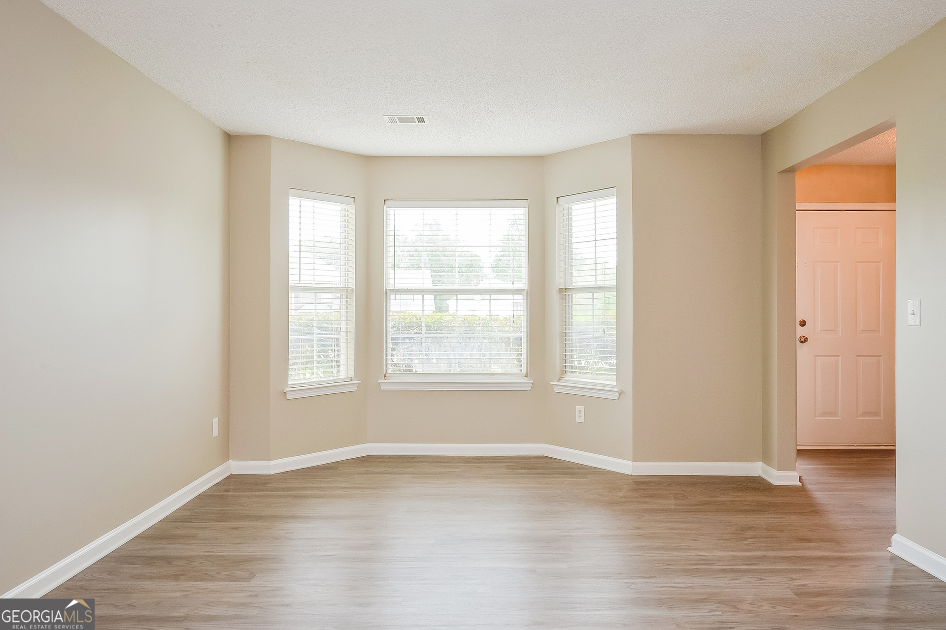 1707 Deer Crossing Way Jonesboro, GA 30236 - Photo 2 of 17 a view of an empty room with wooden floor and a window