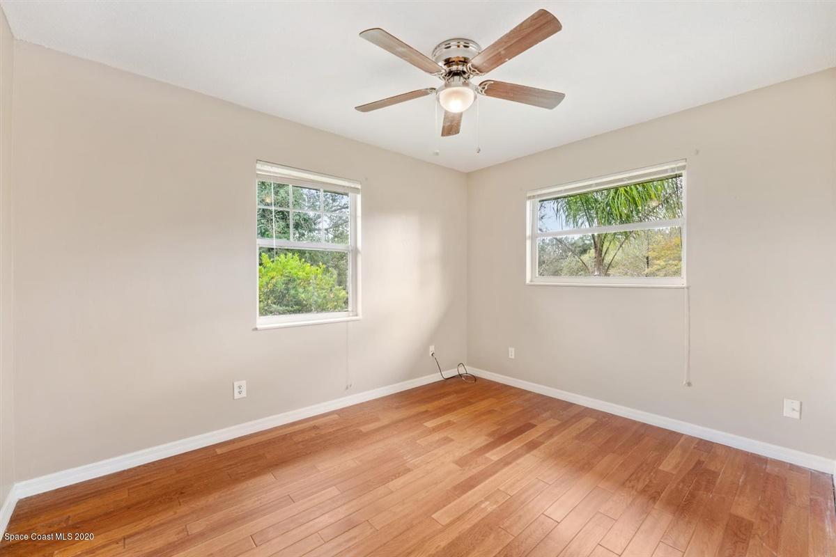 3600 Leghorn Road Grant Valkaria, FL 32950 - Photo 16 of 33 a view of an empty room with wooden floor and a window