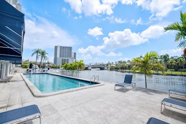 a view of a swimming pool with a lounge chair and floor to ceiling window