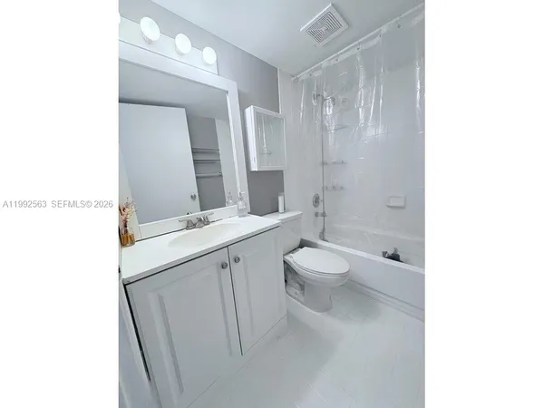 a bathroom with a granite countertop sink a toilet and a mirror