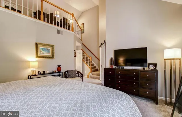 a bedroom with a bed and a flat tv screen on dresser