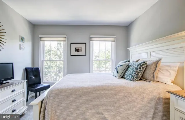 a bedroom with a bed and a tv on the dresser