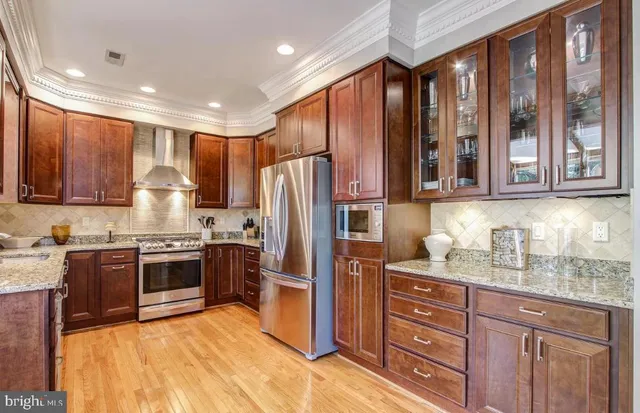 a kitchen with stainless steel appliances granite countertop wooden cabinets a stove top oven a sink and dishwasher