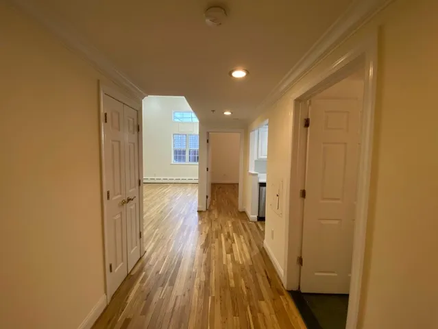 a view of a hallway with wooden floor