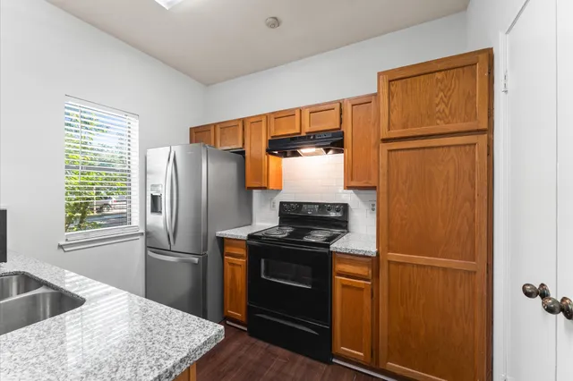 a kitchen with stainless steel appliances granite countertop a refrigerator and a sink