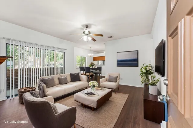a living room with furniture ceiling fan and a window