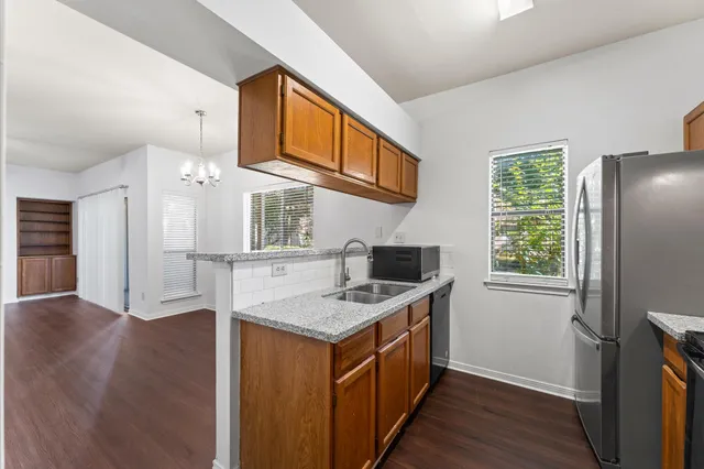 a kitchen that has a lot of cabinets a sink and wooden floor