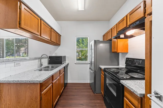 a kitchen with stainless steel appliances granite countertop a sink stove and refrigerator