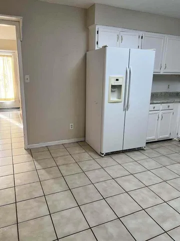a white refrigerator freezer and a stove sitting inside of a kitchen