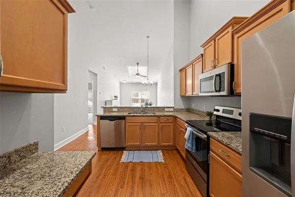 a kitchen with stainless steel appliances granite countertop a stove a sink and a microwave