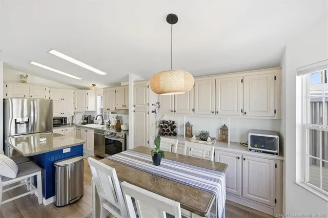 a kitchen with granite countertop a refrigerator stove top oven and sink