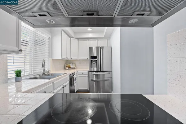 a kitchen with stainless steel appliances granite countertop a sink a refrigerator and a stove