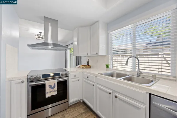 a kitchen with granite countertop a sink stainless steel appliances and cabinets