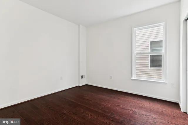 a view of a room that has wooden floor and a window
