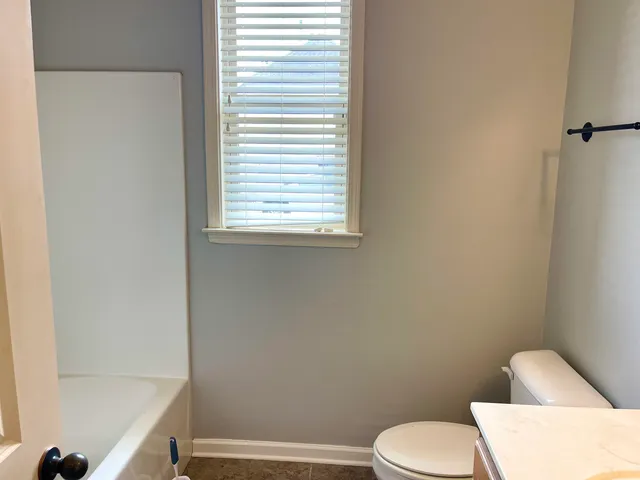a white toilet sitting next to a window