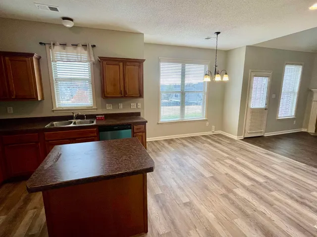 an open kitchen with wooden floor and window