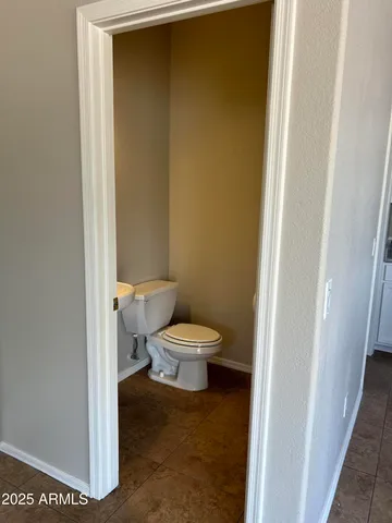a white toilet sitting next to a white wall