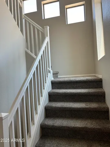 a view of staircase with lots of frames on wall