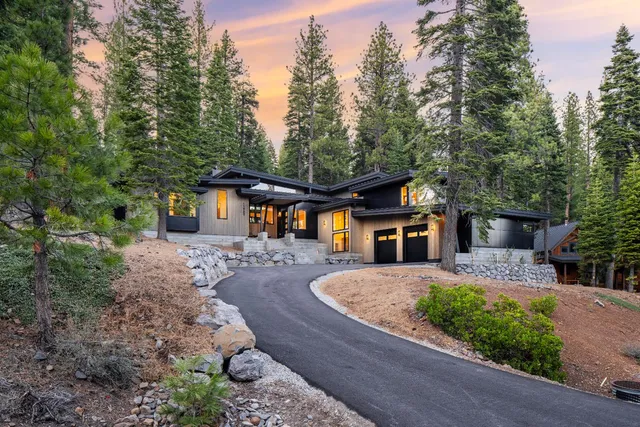 a front view of a house with a yard and trees