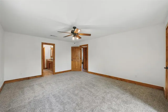 a view of an empty room and a ceiling fan