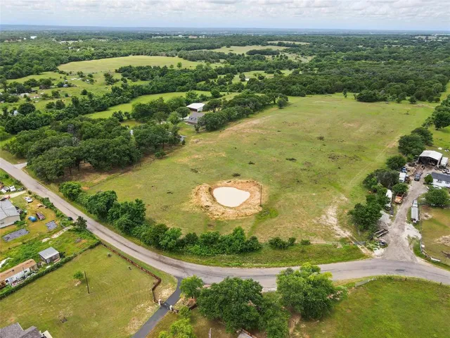 an aerial view of residential houses with outdoor space and lake view