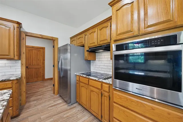 a kitchen with stainless steel appliances granite countertop cabinets and wooden floor