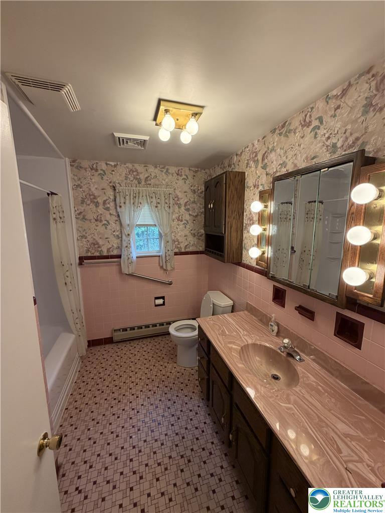 5391 Chapmans Road, Unit 2 Orefield, PA 18069 - Photo 6 of 22 A retro-inspired bathroom features a pink vanity with ample counter space and a patterned tile floor.