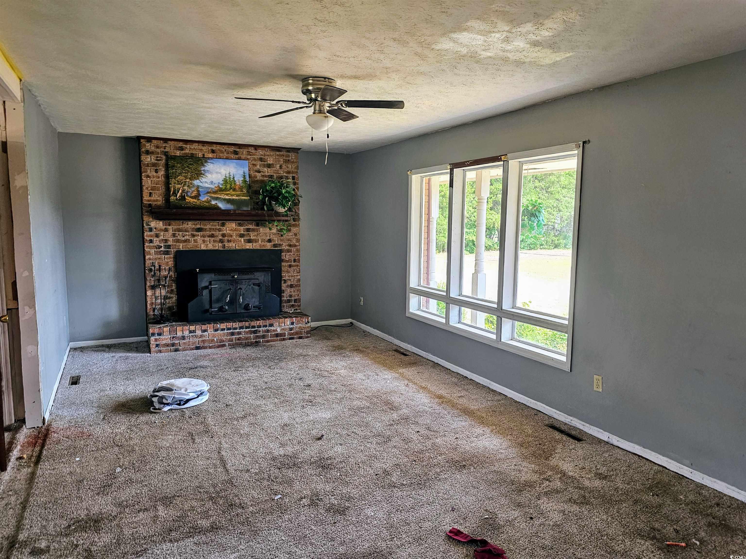 Unfurnished living room featuring a fireplace, a h
