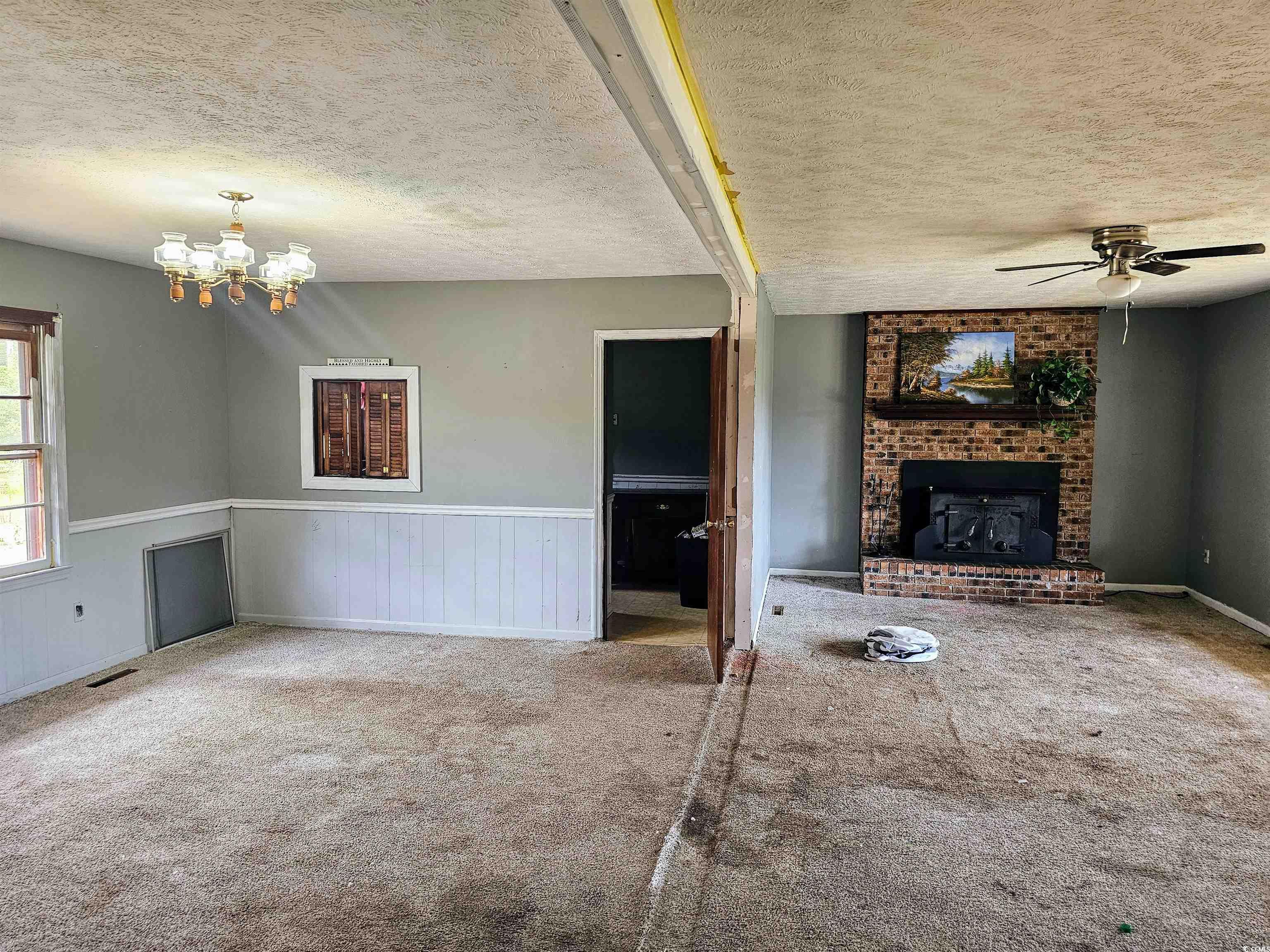 Unfurnished living room featuring a textured ceili