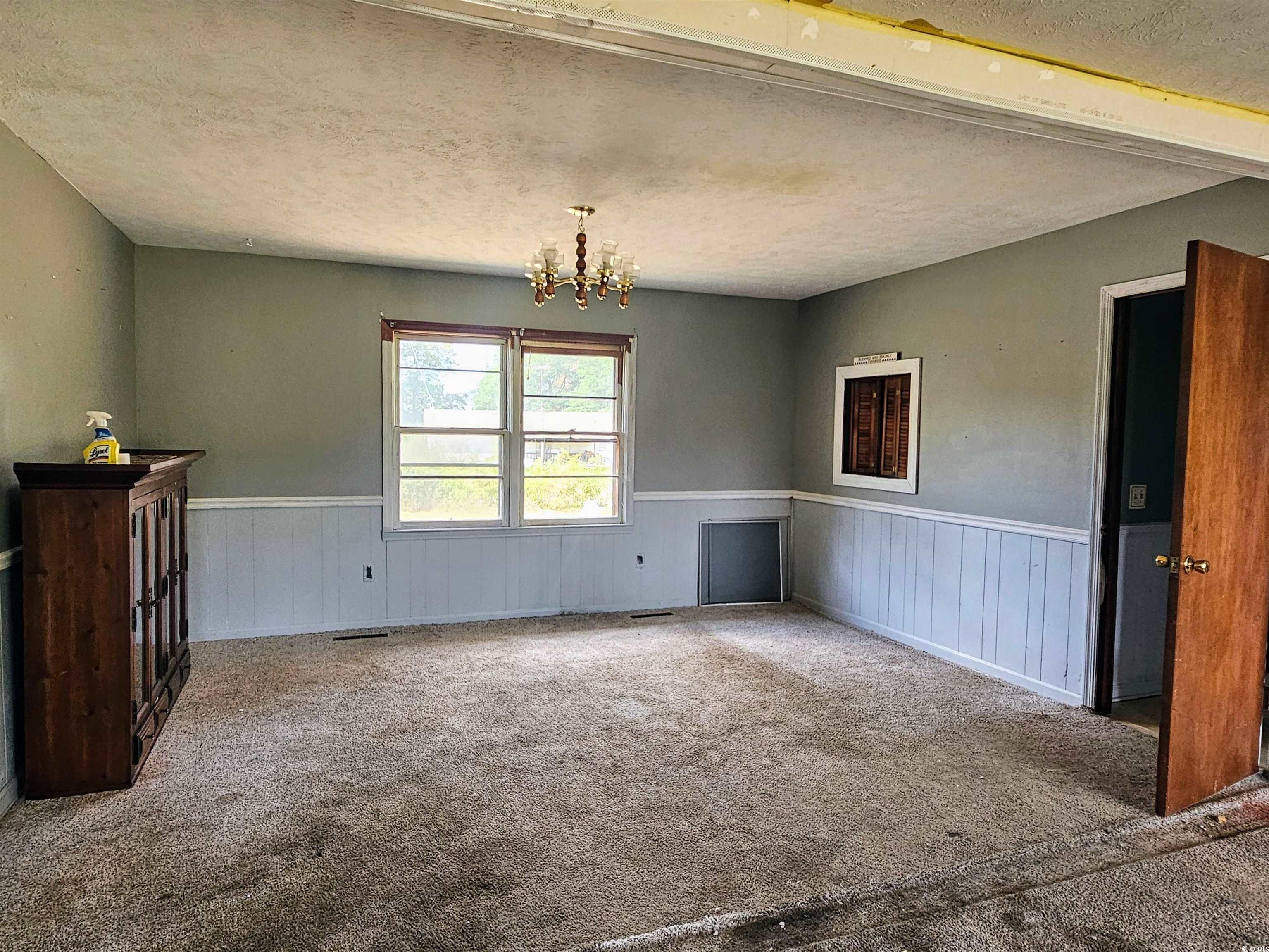 Spare room featuring an inviting chandelier, a tex