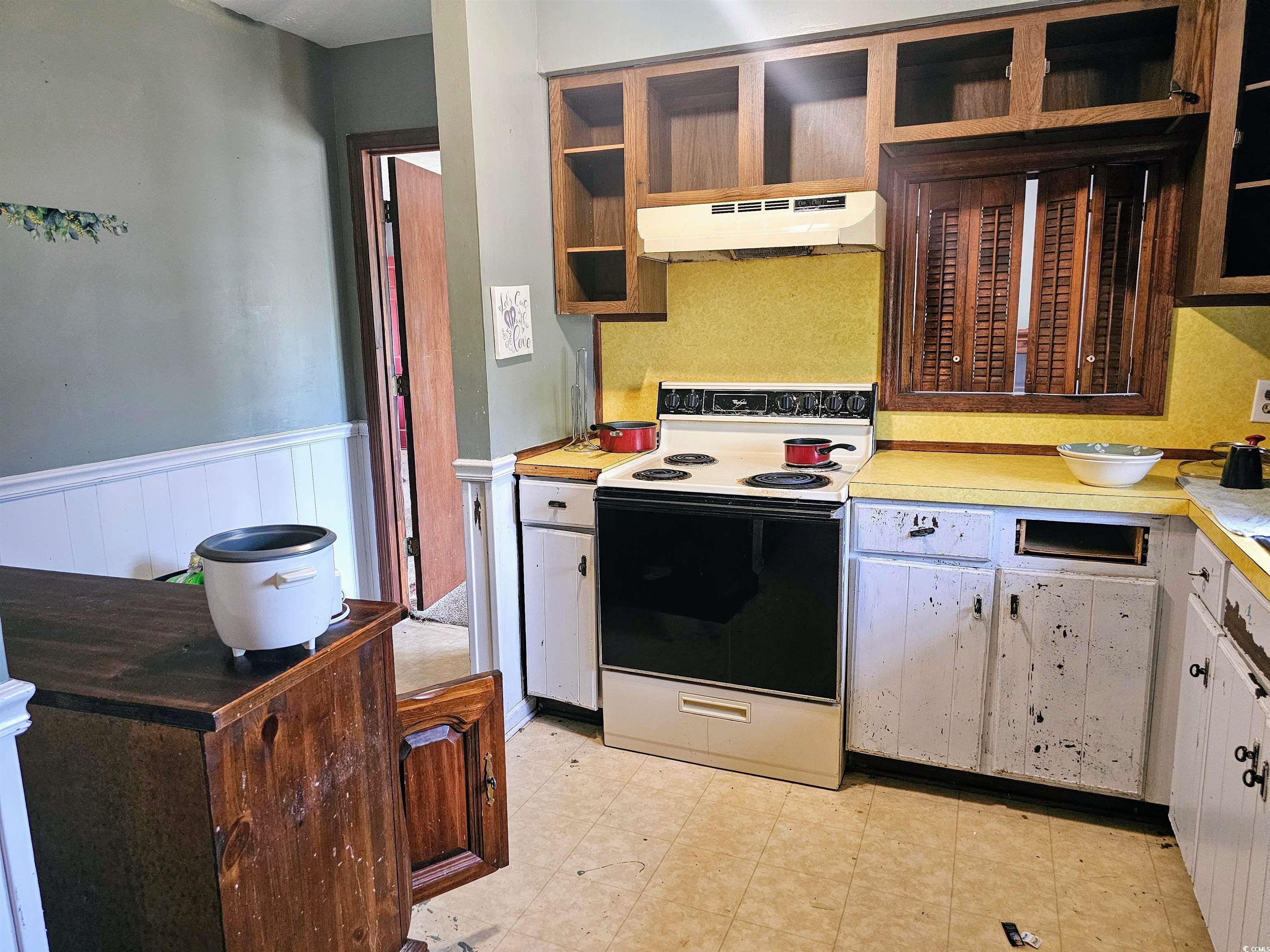 Kitchen featuring white electric stove, light tile