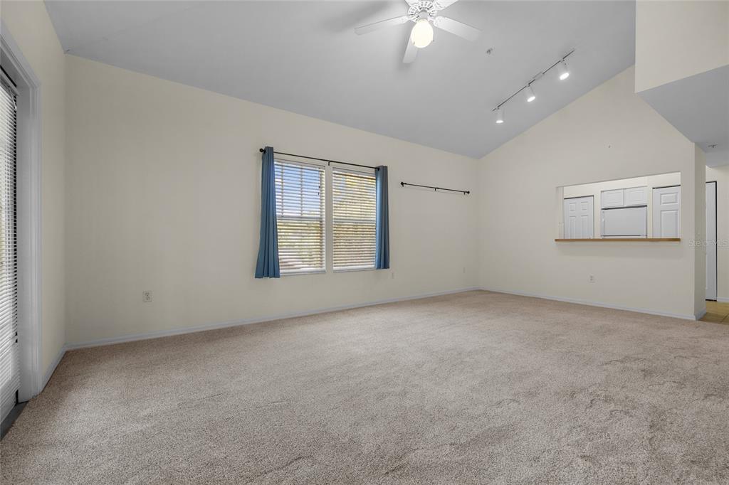 4941 Southwest 91 Terrace, Unit N301 Gainesville, FL 32608 - Photo 12 of 22 an empty room with chandelier fan and windows