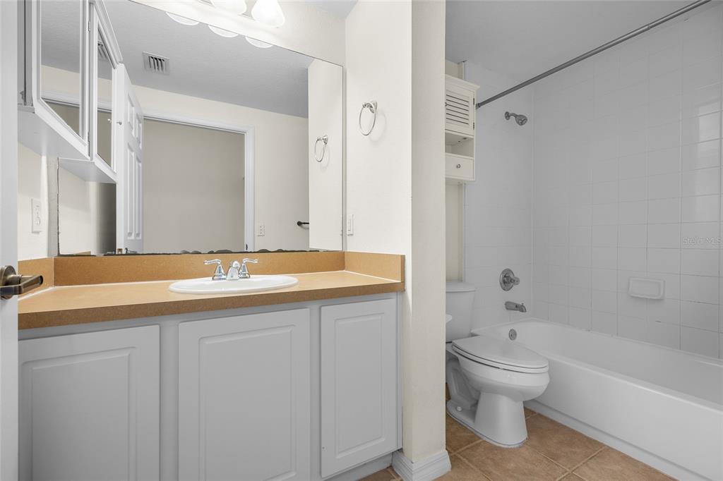 4941 Southwest 91 Terrace, Unit N301 Gainesville, FL 32608 - Photo 16 of 22 a bathroom with a granite countertop sink a toilet and shower