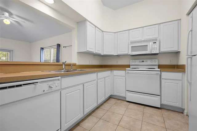 a kitchen with granite countertop white cabinets and sink