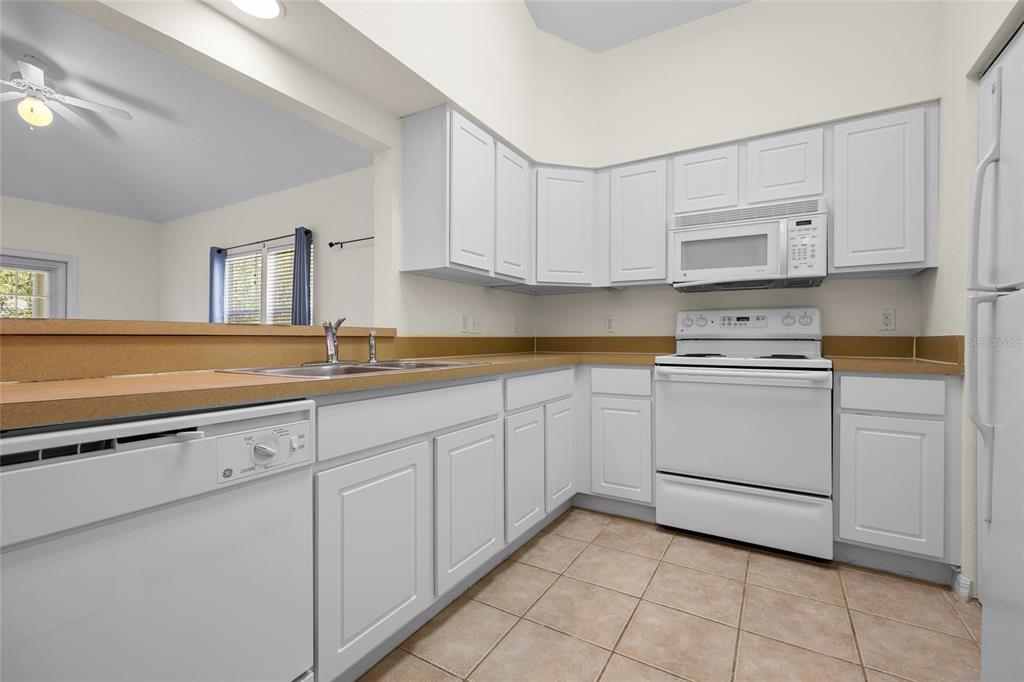 4941 Southwest 91 Terrace, Unit N301 Gainesville, FL 32608 - Photo 4 of 22 a kitchen with cabinets and white appliances