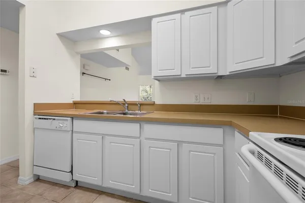 a kitchen with a refrigerator and white cabinets