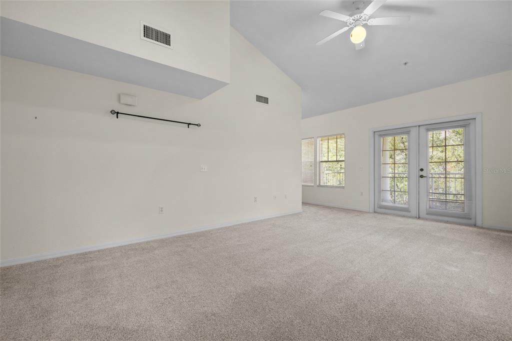 4941 Southwest 91 Terrace, Unit N301 Gainesville, FL 32608 - Photo 7 of 22 an empty room with windows and ceiling fan
