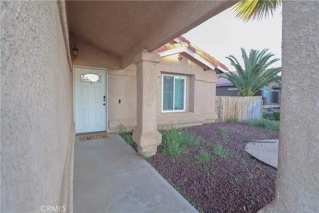 a view of a house with a yard and potted plants