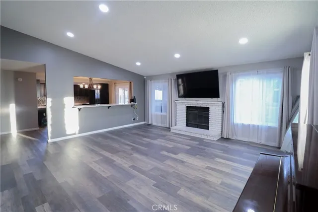an empty room with wooden floor and fireplace