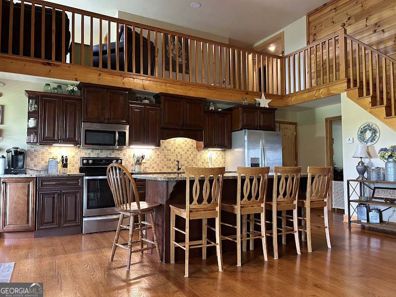 2838 Skitts Mountain Road Cleveland, GA 30528 - Photo 4 of 41 a kitchen with stainless steel appliances kitchen island granite countertop a stove top oven a dining table and chairs
