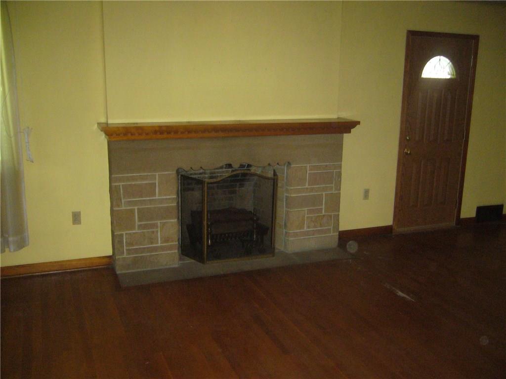 2905 Brodhead Road Aliquippa, PA 15001 - Photo 6 of 14 Living room with stone/gas fireplace and original hardwood floors. The door goes to an outside private porch.
